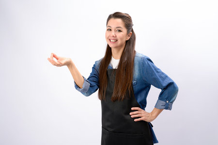 Young female chef in apron show bellissimo perfect gesture on white backgroundの写真素材