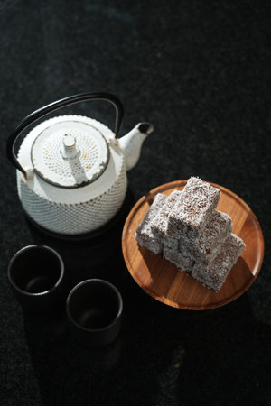 Coffee pot and Turkish delight on a black background, selective focus