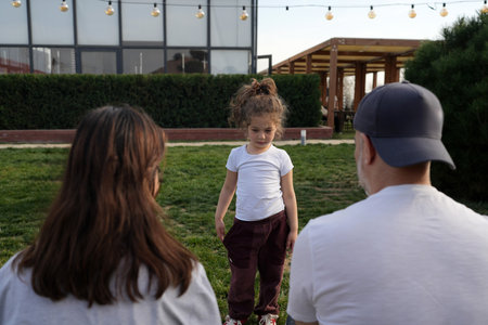 Close-Up of a Loving Family Moment. Portrait of a Caring Father, Mother and daughter. Happy Family Embracing in Front of Their Modern Home, outdoorsの写真素材