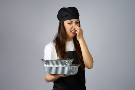 Young Woman Pinching Her Nose at Takeaway Containers