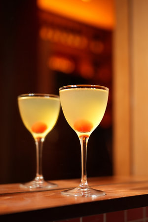 Classic cocktail glass with cherry in a bar counter, close-upの写真素材