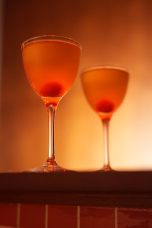 Classic cocktail glass with cherry in a nightclub bar counter, close-upの写真素材