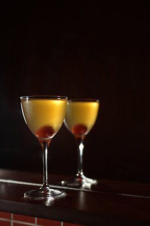 Classic cocktail glass with cherry in a nightclub bar counter, close-upの写真素材