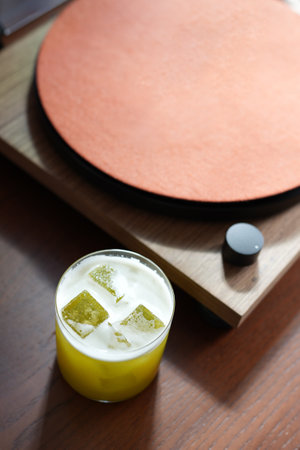 Vibrant yellow cocktail served in a rocks glass filled with ice. The drink has a frothy, white top, sour cocktailの写真素材