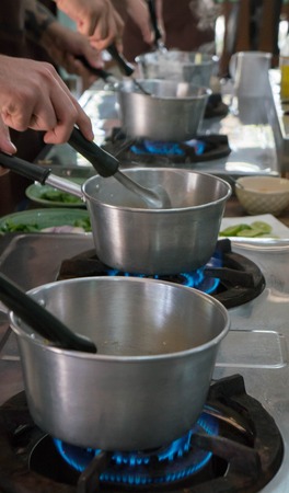 Stainless steel pots on gas burnersの写真素材