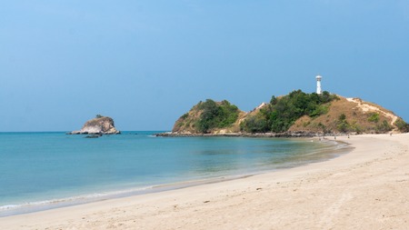 Lighthouse on a hill at the beach on Koh Lanta, Thailand, with a tiny uninhabitated island right next to it.の写真素材