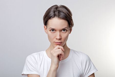Close up of beautiful, calm, attractive young girl, one arm under the chin, look confident,...