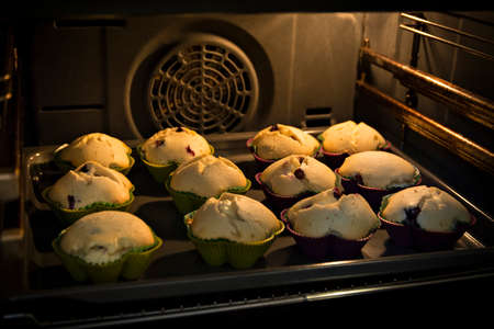 Muffins cooking in the ovenの写真素材