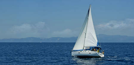 White sailboat traveling the sea