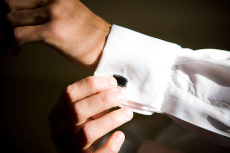 A man buttons up his cuff