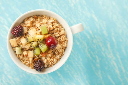 Oat flakes plate with honey, banana, egg, walnut on a turquoise wooden table. 45 degrees view of healthy oat flakes breakfast. Copy space. Selective focus.の写真素材