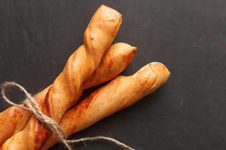 Three baguettes tied with each other on black painted background. Top viewの写真素材