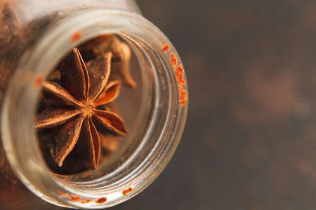 Close up pho to of old glass jar with star anise seeds on a dark background. Selective focus