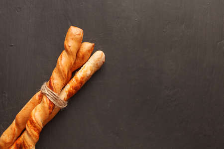 Three baguettes tied by jute twine on dark background with copyspace. Top viewの写真素材