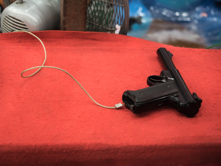 black toy gun on red table at a Temple Fair in Bangkok , Thailandの写真素材