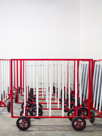 Red and white steel barrier guard with wheel in storageの写真素材