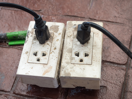 Close-up of old socket, electrical outlet with plug on groundの写真素材