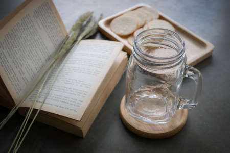 Empty glass cup and book on the tableの写真素材