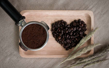 heart from coffee beans and wooden spoons with coffee maker prepared on the desktopの写真素材