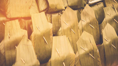 steamed rice dough with sweet coconut stuffing. Thai dessert. also called "ka-nom-sai-sai" in Thai style packaging from banana leafの写真素材