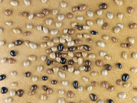 Color river pebbles on sand backgroundの写真素材