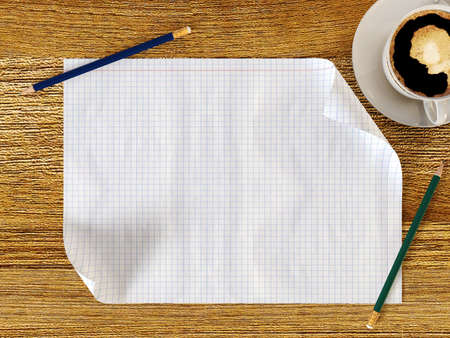 Blank paper on wood table with pencils and coffee cupの写真素材
