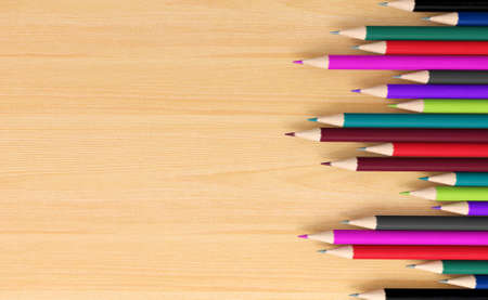 Colored pencils on wooden board with space for textの写真素材