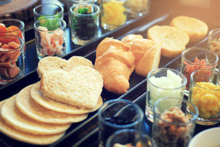 Croissants and breads with various ingredients for breakfast mealの写真素材