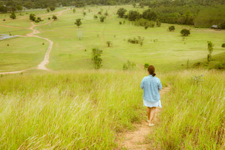 Woman on hill and green grassの写真素材