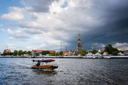 The boat was sailing in Chao Phraya River, background Wat Arun ,Bangkok, Thailand. The Temple of Dawnの写真素材