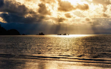 Bright sun light, rays of light shine in water, sunbeam in cloudy sky, summer ocean view,KOH PHAYAM ISLAND, RANONG, THAILANDの写真素材