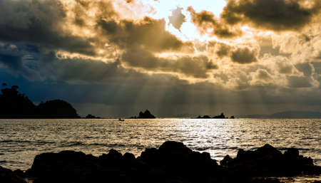 Bright sun light, rays of light shine in water, sunbeam in cloudy sky, summer ocean view,KOH PHAYAM ISLAND, RANONG, THAILANDの写真素材