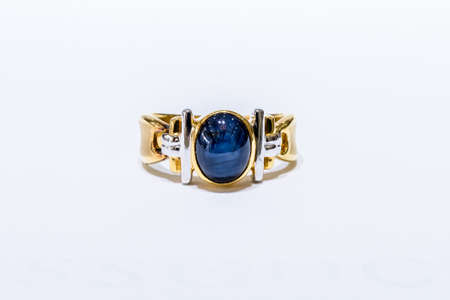 Gold ring with big sapphire on white backgroundの写真素材