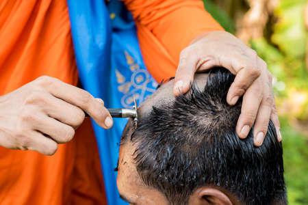 Man Shaving hair,before ordained as a monk , this is Culture of Thailand