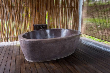 Open air bathroom, Marble bathtub with Bamboo backdrop and Wooden floorの写真素材