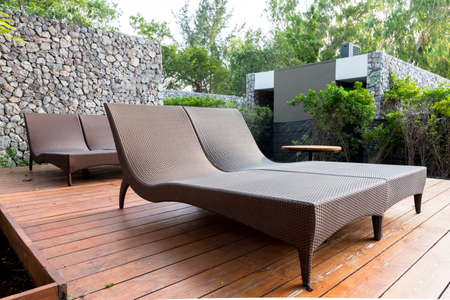 chaise longues in the garden beside swimming pool.の写真素材