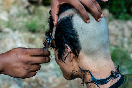 Man Shaving hair,before ordained as a monk , this is Culture of Thailandの写真素材