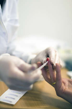 A doctor is taking a blood sample from patient.