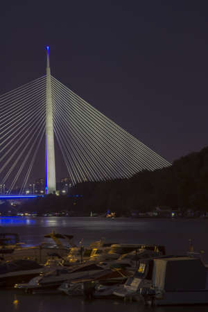 Night shot of Ada bridge, Sailing boats in marina are in the foreground. On Sava River, in Belgrade, Serbiaの写真素材