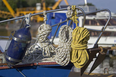 Tied up ropes and Buoys on a sailboat hanging from the railの写真素材