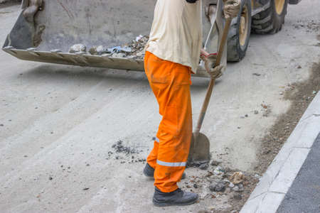 Preparation apply the first layer of asphalt during road construction, cleaning rubble from the...
