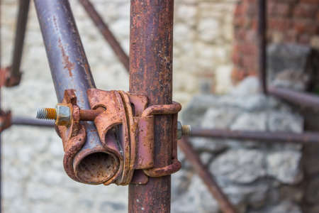 Detail of vintage and rusty scaffolding clamp with pipesの写真素材