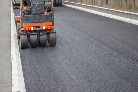 mini compactor roller during road construction at asphalting workの写真素材