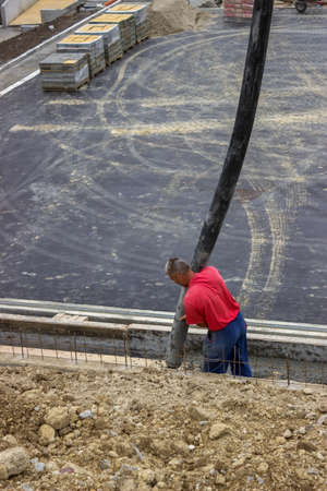 Worker pouring concrete on retaining concrete Wall, aiming pump tube during concrete pouring 
の写真素材