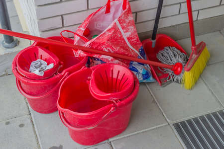 Household cleaning supplies sitting at the entrance to the apartment buildingの写真素材