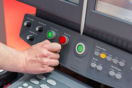 Close of hand using control panel of a cnc machine. Programmable machine. Selective focus and shallow dof.の写真素材