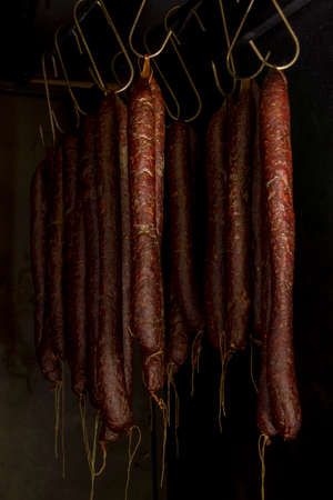 Smoked sausages hanging in smokehouse, smoked sausages in traditional way. Selective focus.