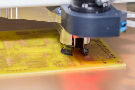 CNC drill machine drilling a printed circuit board. Drilling PCB holes. Selective focus and shallow dof.の写真素材
