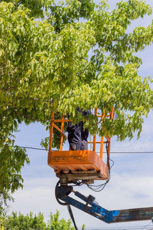 Electrical worker in lift bucket during repair the power line.  Utility worker replacing cables. Selective focus and shallow dof.の写真素材