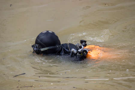diver in diving suit and mask removing river hazardsの写真素材